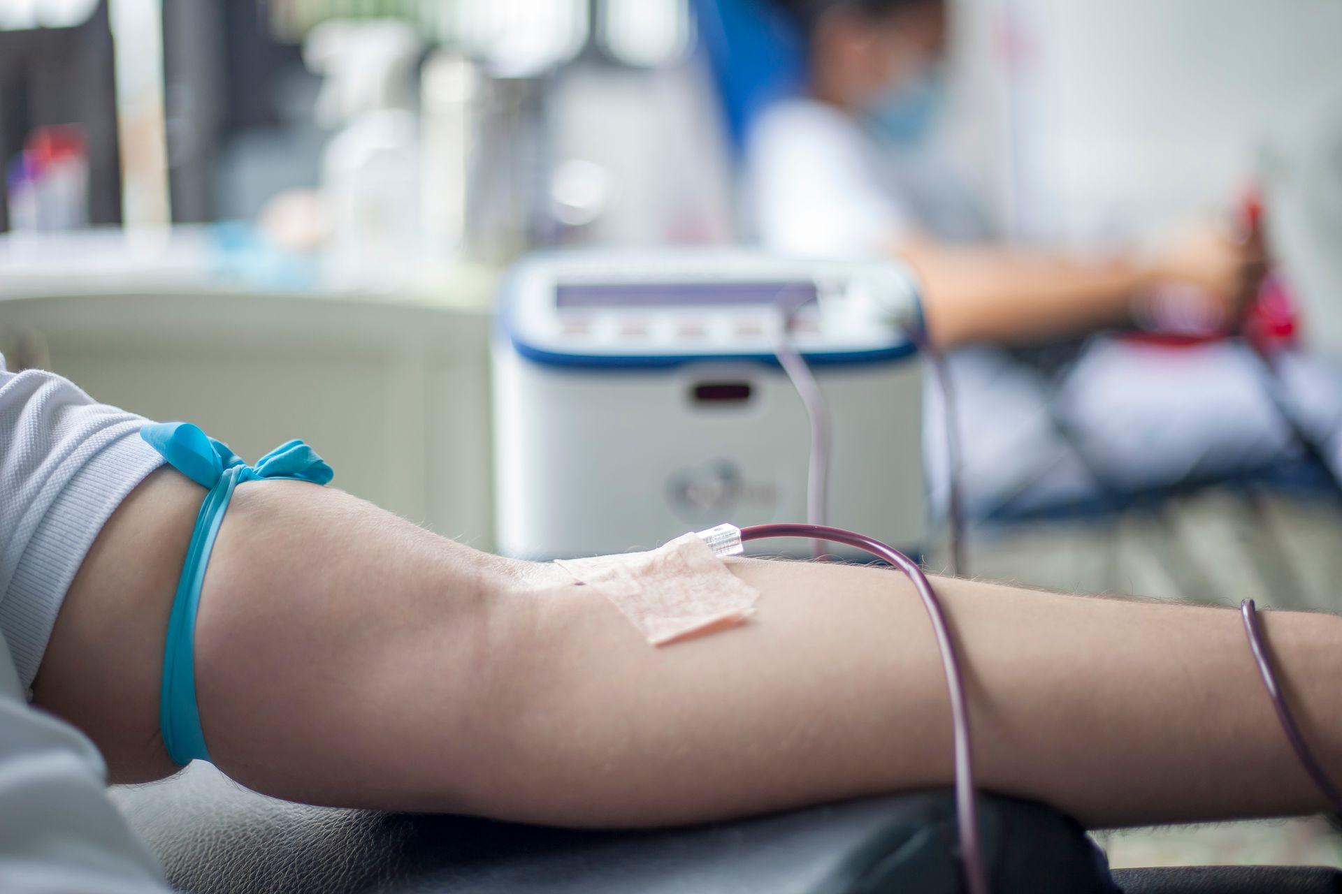 Person relaxing in a clinic chair donating blood to manage secondary erythrocytosis on TRT